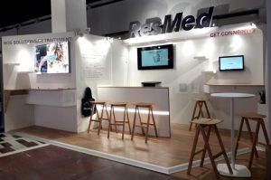 Stand sur mesure Media Product pour ResMed au salon JESFC 2019 à Paris, intégrant un espace d'accueil, des écrans de démonstration et des comptoirs.